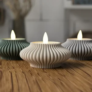Três porta-velas ondulados em verde, branco e cinza com velas LED